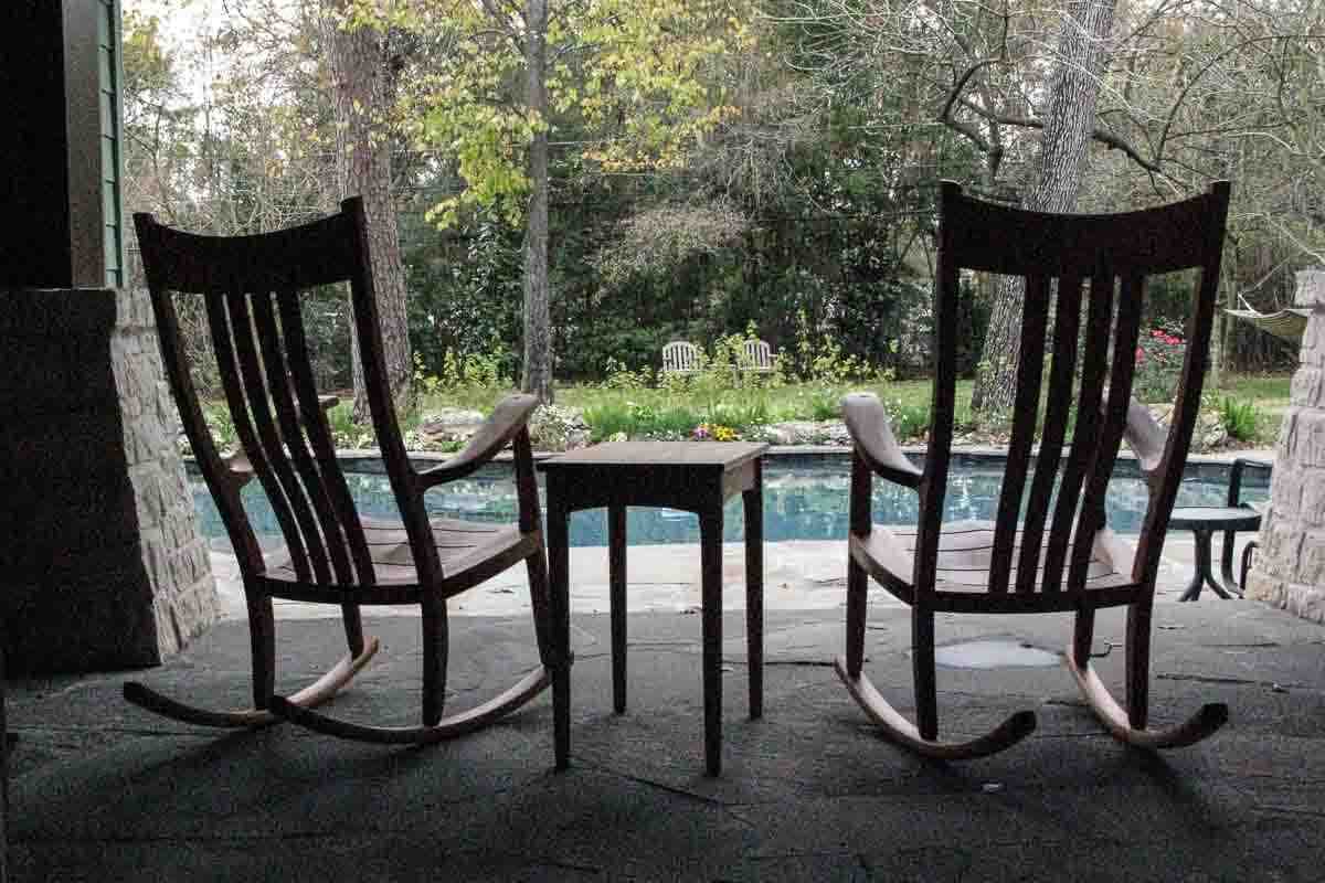 two mahogany porch rockers by a pool